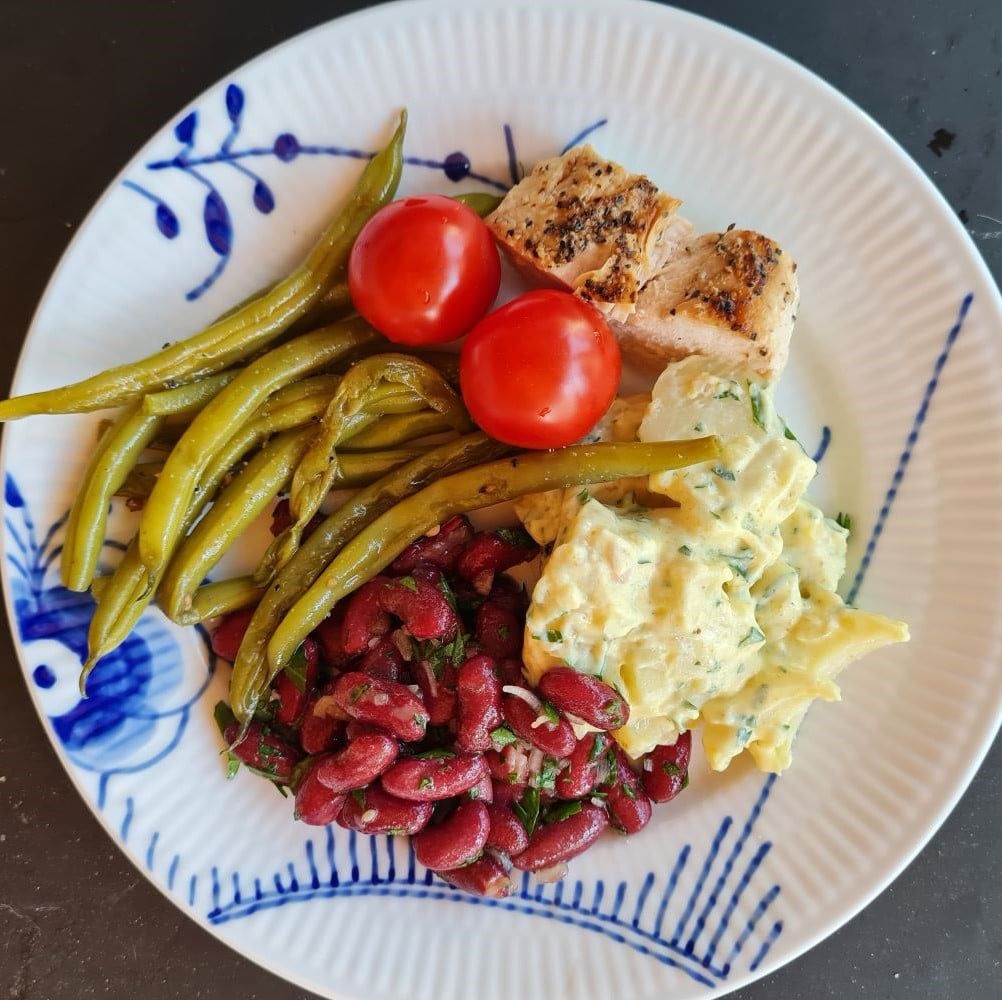 Middagsretter ved kræft her illustreret ved dampede grønne bønner, kidneybønnesalat, kartoffel eller jordskokkesalat og dampet laks. Anrettet på megamussel frokosttallerken.