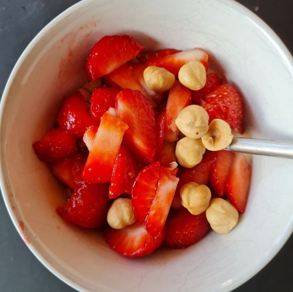 Soyayoghurt (naturel) m glutenfri havregryn, ristede hasselnødder og jordbær i hvid skål