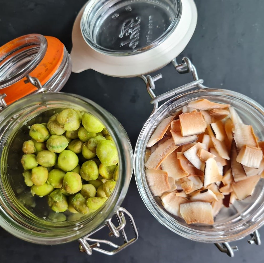 Det søde og snacks ved kræft illustreret ved 2 små patentlågsglas. Det ene med wasabinødder det andet med usødede kokosflager. Lågene står åbne.