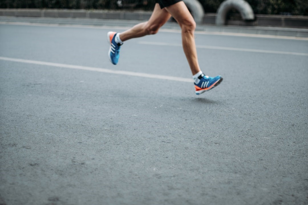 Maratonkvinden illustreret ved kvinde i løb på asfaltvej. Man ser kun benene. Hun har turkise løbesko på."