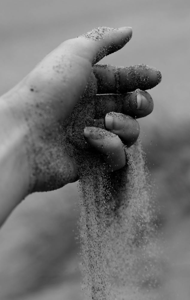 Følelser når diagnosen kræft er stillet. Angst og usikkerhed. Med tiden kommer der mere styr på følelserne. Her symboliseret ved en hånd med sand, hvor sandet løber ud mellem fingrene.