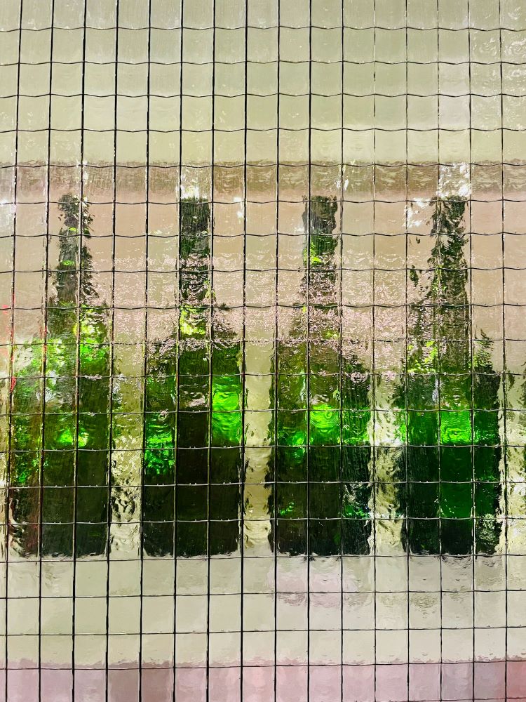 Gemini censurerer symboliseret ved 4 flasker med grønt indhold, der står bag noget uklart glas med metalnet.