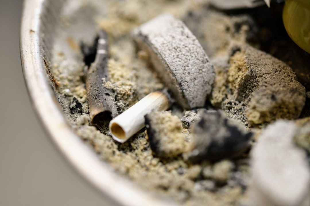 Lungekræft symboliseret ved cigaretskod liggende i potte med aske og forkullede træstykker.