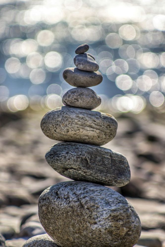 Mindfulness symboliseret ved en lille zen-inspireret stenskulptur af enkelte lidt flade sten stablet ovenpå hinanden.