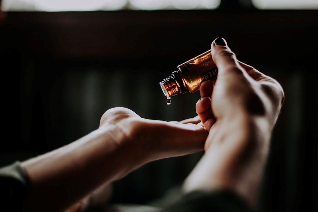 Hormonterapi - naturlig - symboliseret ved et sæt hænder, hvor den højre holder en lille brun flaske, hvorfra der dryppes dråber i håndfladen på den anden hånd.