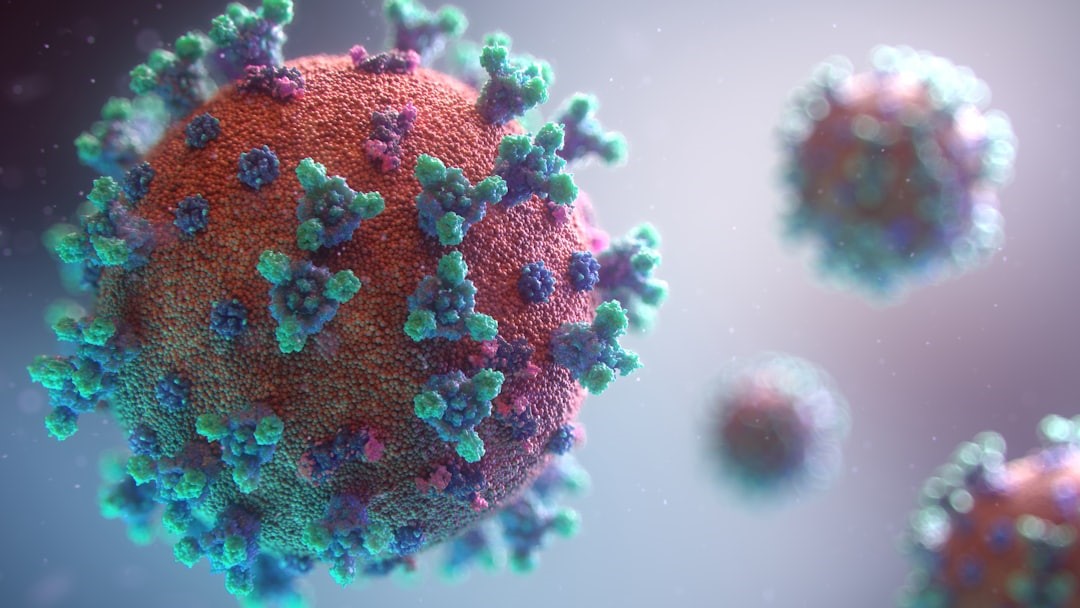 Virusterapi symboliseret ved forstørrelse af virus, der er orange, med blå og turkise vækster på ydersiden.