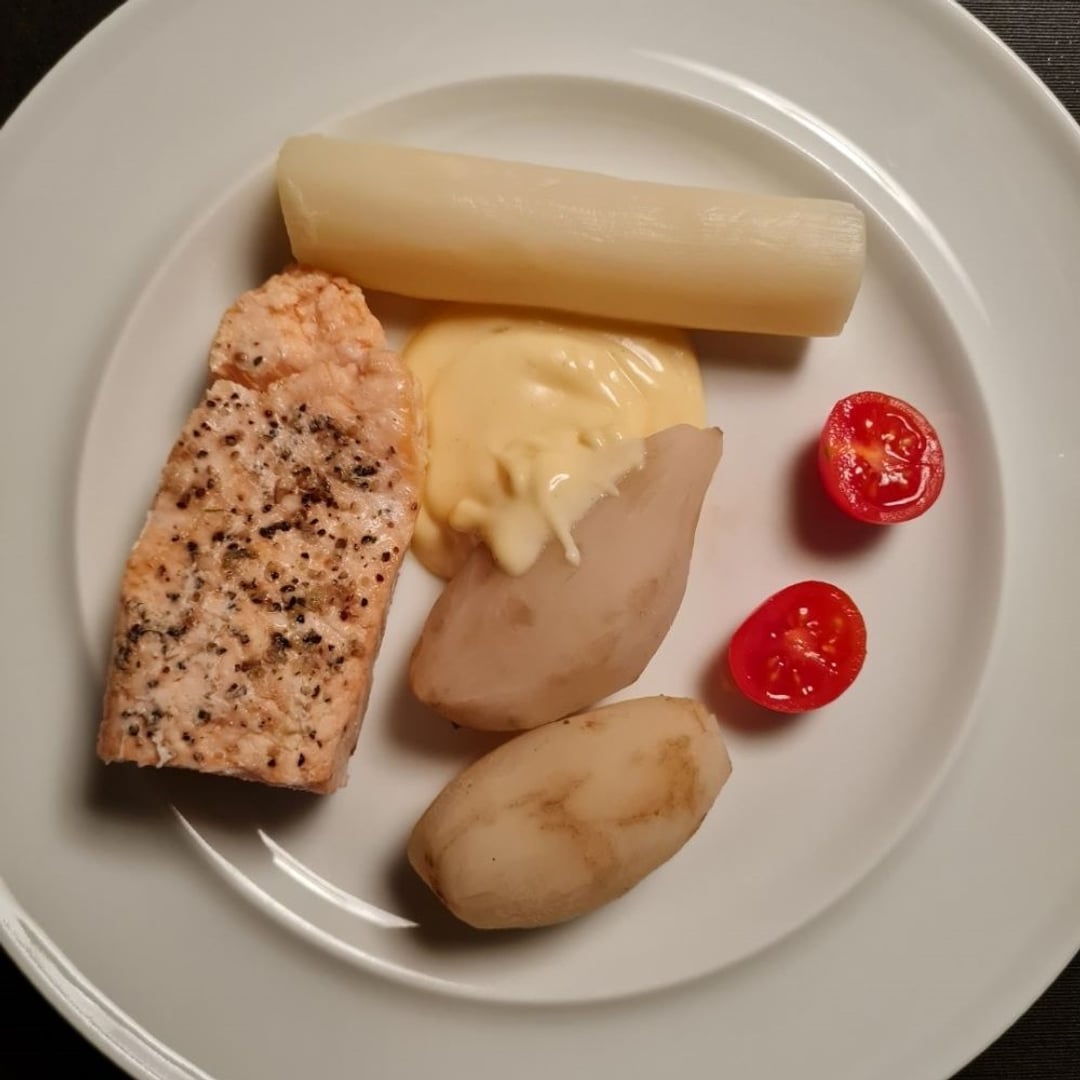 Bagt laks m. jordskokker, asparges, tomater og hollandaisesauce på hvid tallerken.