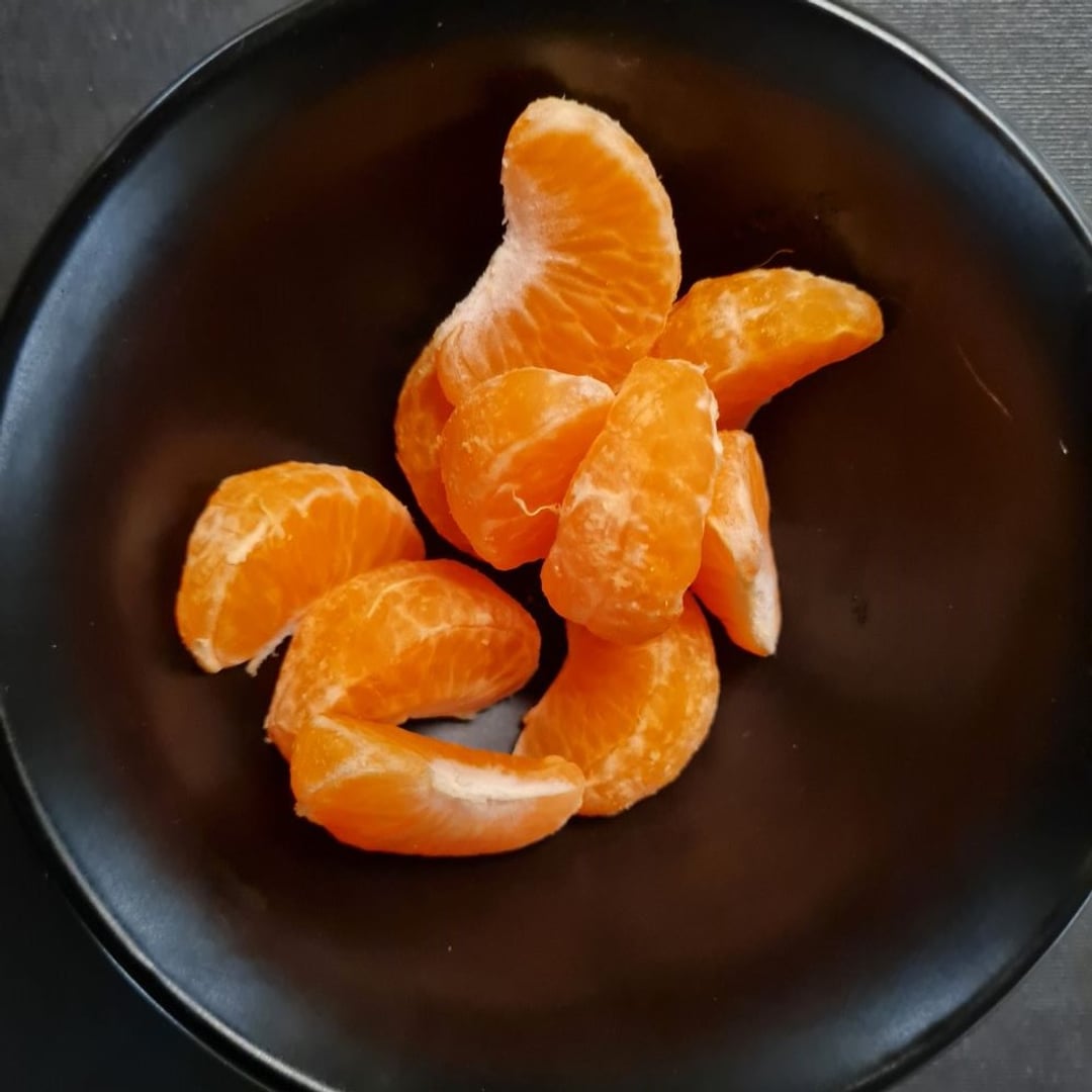 Skiver fra en lille pillet klemmentin i sort skål.