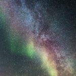 Nærdødsoplevelse symboliseret ved stjernehimmel med flerfarvet nordlysagtigt skær.