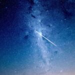 Nærdødsoplevelse symboliseret ved et stjerneskud på en blå stjernefyldt himmel.