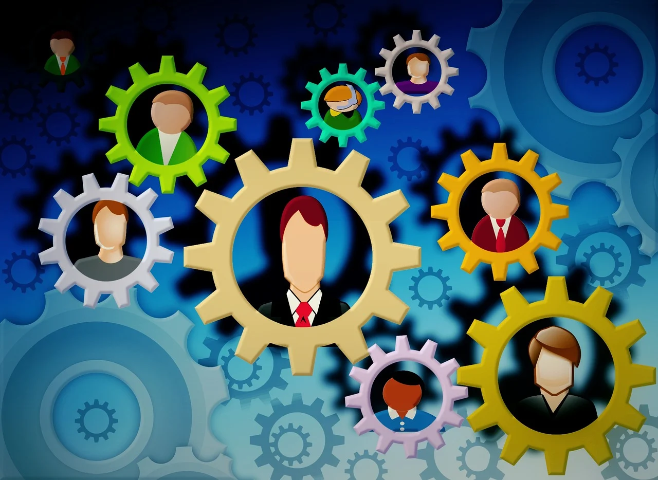 Pårørende symboliseret ved tegning af en masse tandhjul med ansigter i. De har forskellig farve og størrelse. Baggrunden er lys turkis i bunden og toner over til at blive mørk blå i toppen.