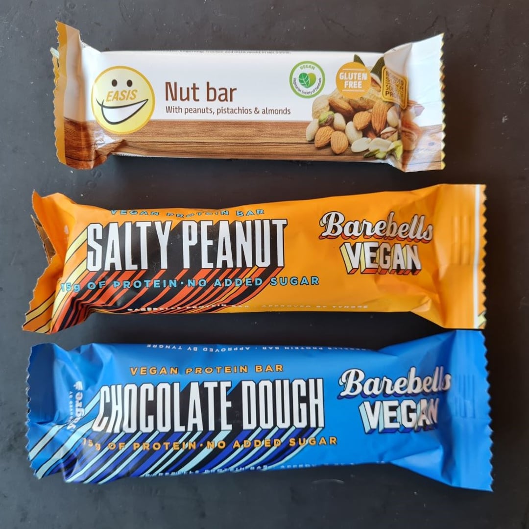 Tre proteinbarer i vegansk og sukkerfri udgave. De to er fra Barabell, den ene lys blå og den anden orange. Den sidste er en Nøddebar fra Iasis.