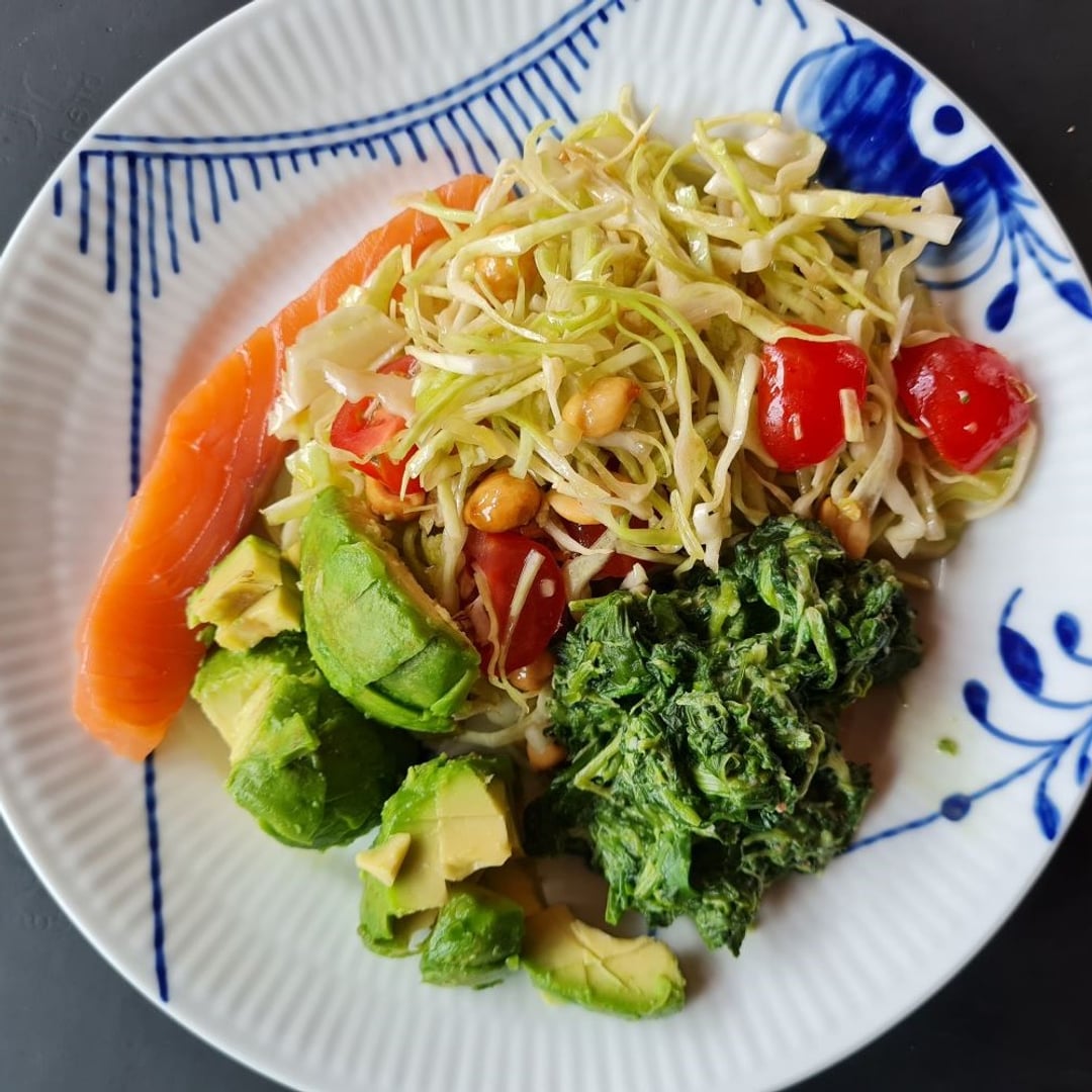 Røget laks med spidskålssalat m. tomater og peanuts, havrefløde-stuvet spinat og avocado placeret på blå mega-mussel tallerken.