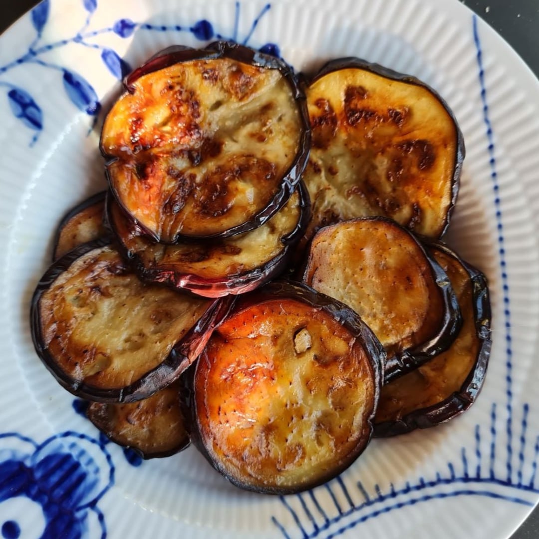 Stegt aubergineskiver i lag på blå mega mussel tallerken