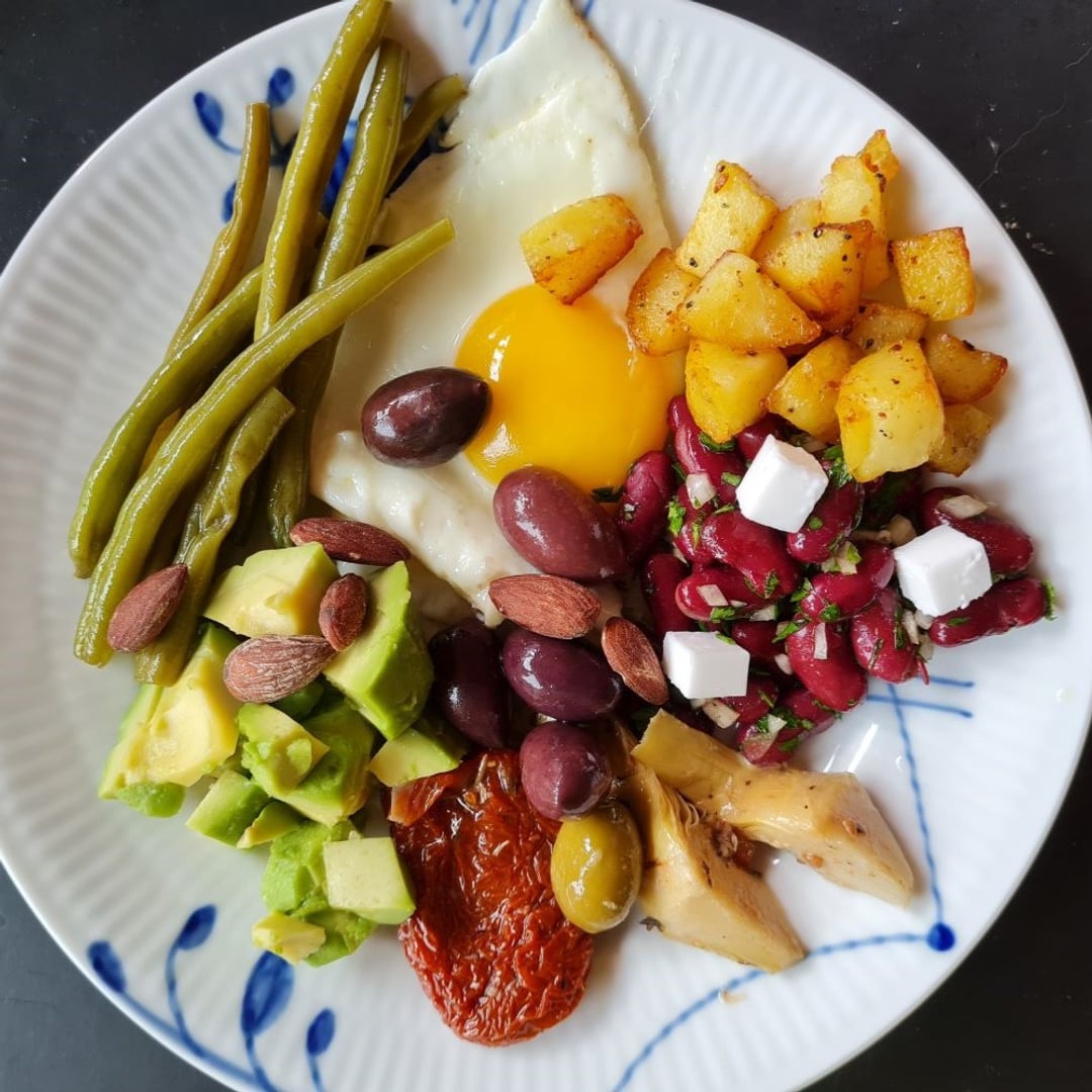 Tapas af Spejlæg, Kidneybønnesalat m soyafeta, Brasede nye kartofler/jordskokker,
Kalamata oliven,
Avocado, Stegte grønne bønner, Artiskokker,
Soltørrede tomater, Saltmandler. Alt placeret på blå megamussel tallerken.