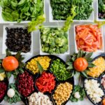 Vegansk kost symboliseret ved mange små, fortrinsvis firkantede skåle, med forskellige grøntsager. Herunder sorte oliven i skiver, salat, broccoli, tomat, kidneybønner, majs, rød peber, champignon mm.