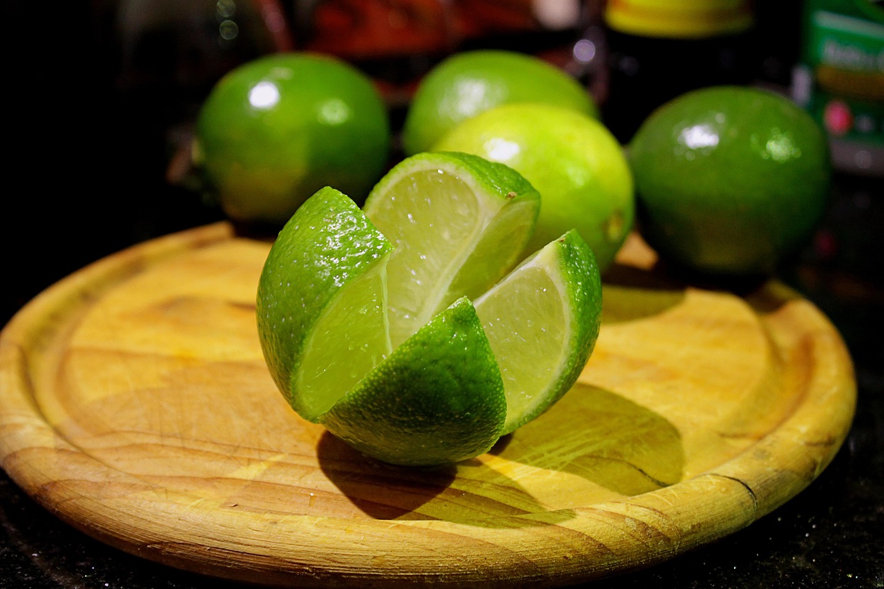 Vitamin-C oralt symboliseret ved en lime, der er opskåret i kvarter og med flere hele liggende bagved denne.