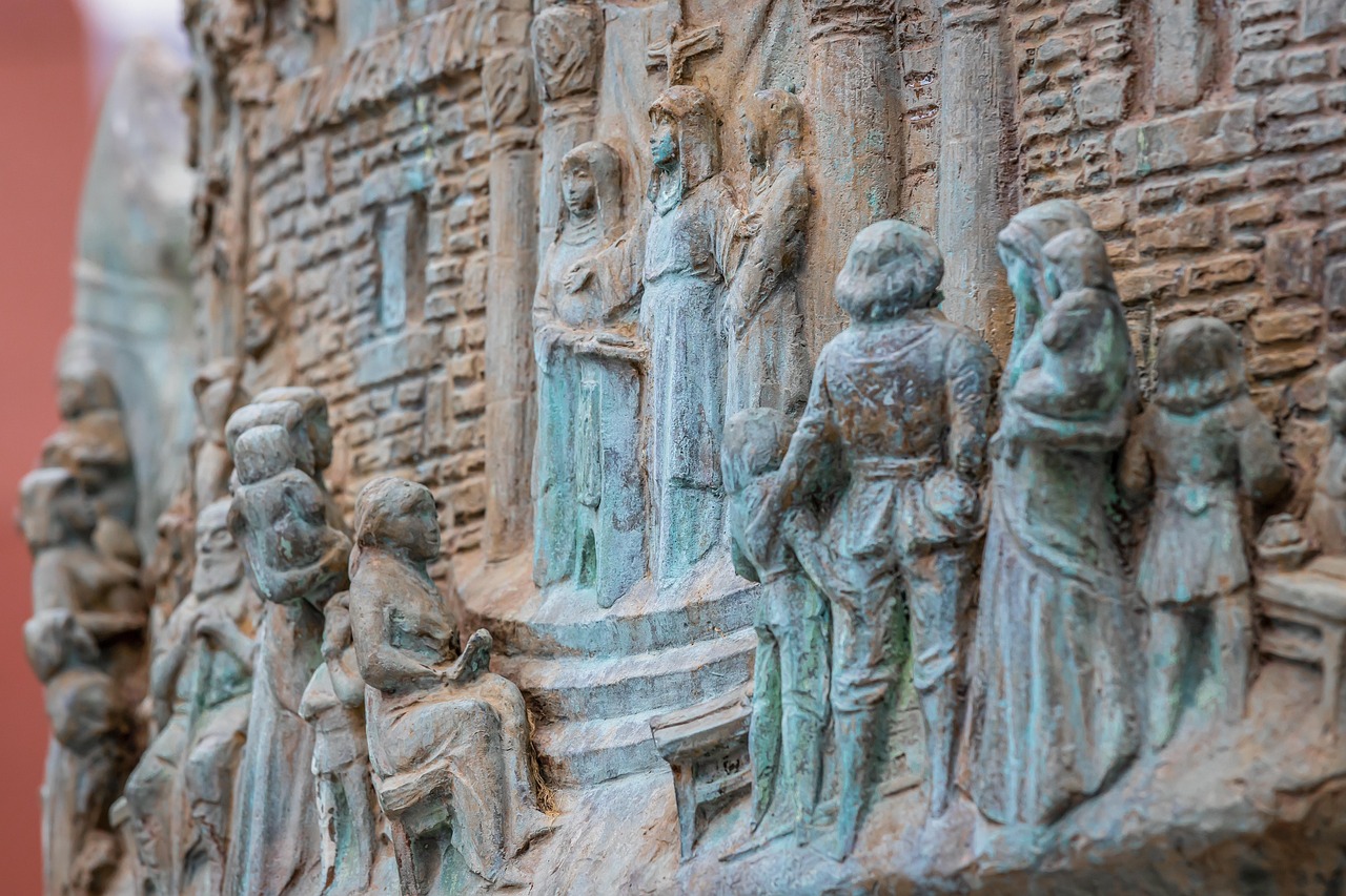 Hildegard von Bingen symboliseret ved stentavle-skulpturer i grå-brune nuancer.