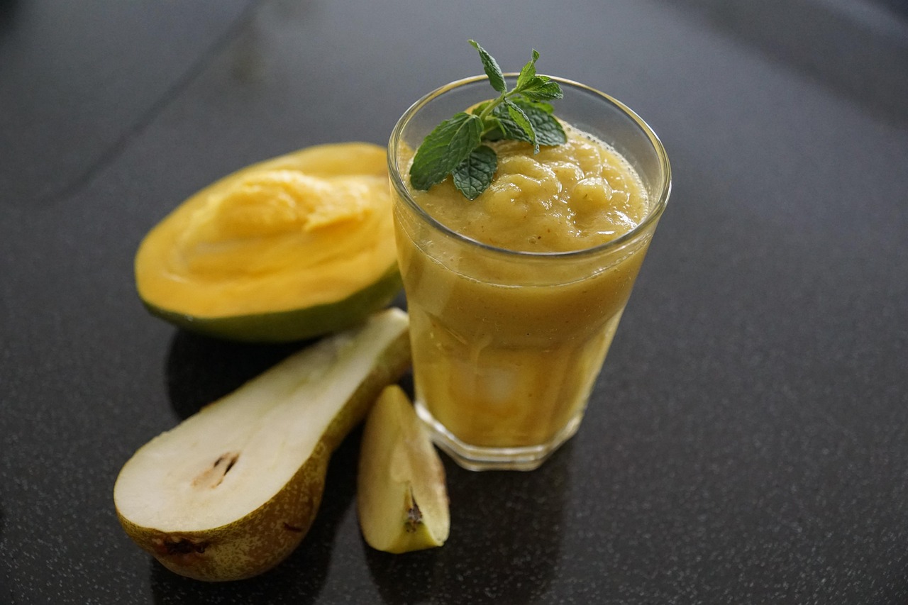 Diarré symboliseret ved et glas med frugtmos og en halv pære og lidt melon liggende ved siden af denne.