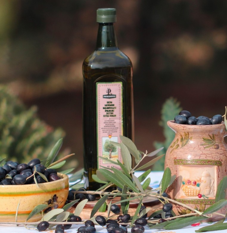 Dæmp inflammation symboliseret ved en flaske olie og nogle sorte oliven der ligger foran og i en skål til venstre og en høj krukke til højre.