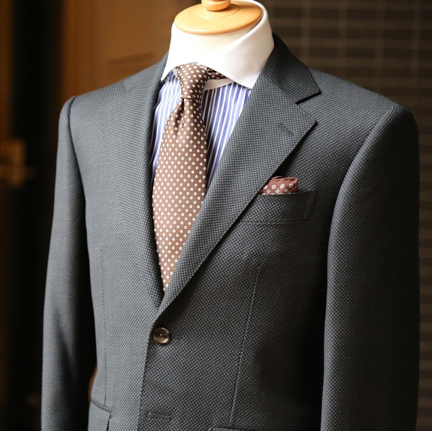 Tøj og tekstiler symboliseret ved en gine med jakke, skjorte og slips.