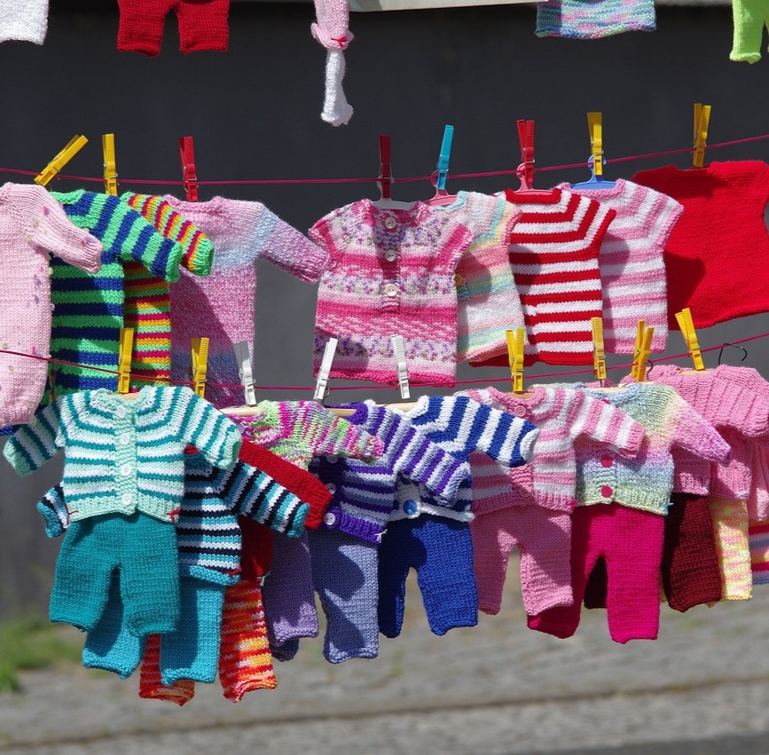 Tøj og tekstiler symboliseret ved en masse børnetøj der hænger på snore.
