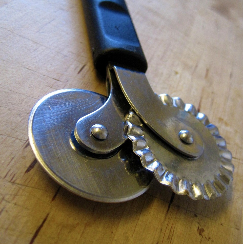 Kost som redskab symboliseret ved en dejskærer med to hjul - et glat og et bølget.