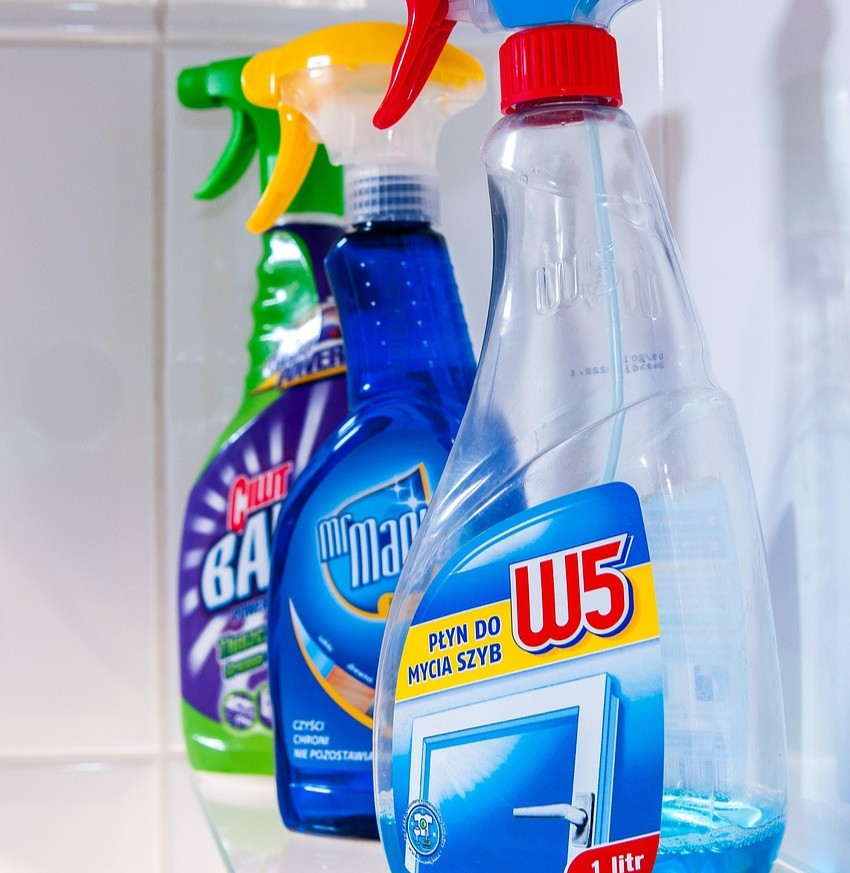 Rengøring og vaskemidler symboliseret ved forskellige typer sprayflasker med rengøringsmidler. Ajax mm.