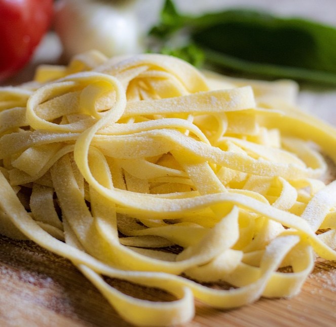 Gluten og kræft symboliseret ved frisk båndpasta.