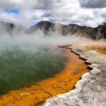 MSM. Methylsulfonylmethan - svovl - symboliseret ved kyststrækning med kraftige orange svovlaflejringer i vandkanten. Bjerge i baggrunden.