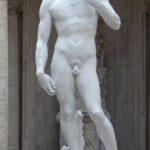 Peniskræft symboliseret ved hvid mandeskulptur.