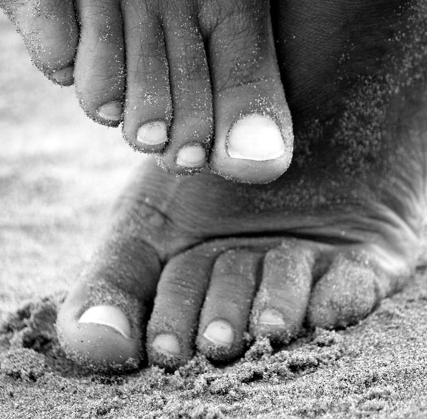 Subungualt Melanom symboliseret ved et sæt fødder i sand.