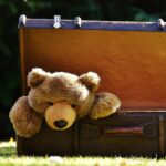 Gaver symboliseret ved en bamse der sidder i en kuffert.