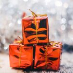 Gaver symboliseret ved orange skinnende indpakning af 3 gaver.