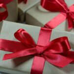 Gaver symboliseret ved grå gavepakker med røde silkebånd.