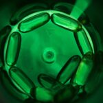 Medicinsk logistik symboliseret ved nogle grønne kapsler der ligger cirkulært.