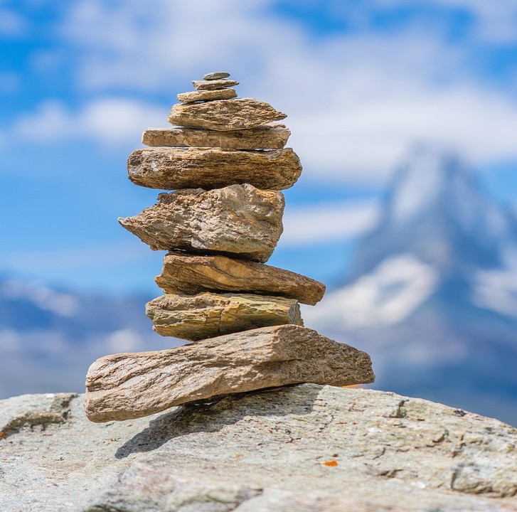 Pete Sulacks protokol symboliseret ved en zen-stenbunde med blå himmel som baggrund.