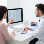 Essentiel Trombocytose symboliseret ved en skærm foran denne en mandlig læge i hvid kittel og en kvindelig patient.