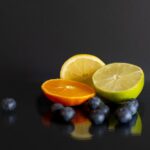 Protokoller ved kræft symboliseret ved citrusfrugter halverede og nogle blåbær. Mørk baggrund.