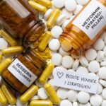 Bomber, brandslukkere og timing symboliseret ved 3 pilleglas med hvide piller og guld kapsler der ligger spredt ud mellem hinanden.