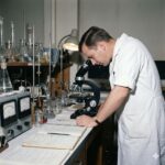 Beljanski Protokollen symboliseret ved en mand der står i et laboratorie og kigger i et mikroskop.